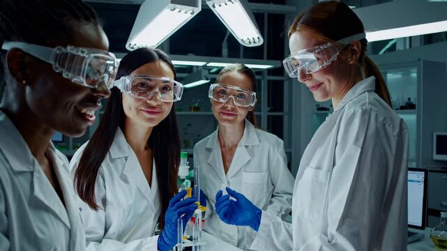 Grupo de estudiantes mujeres realiza experimentos qu&iacute;micos con tubos de ensayo en laboratorio moderno, representando inclusi&oacute;n y vocaci&oacute;n STEM.