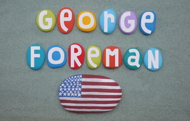 George Foreman, heavyweight boxing legend celebrated with multi colored hand painted stones over green sand