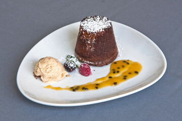 Delicious chocolate fondant with red berries, passion fruit sauce and walnut ice cream, desserts