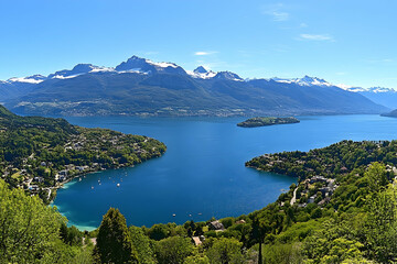 Panoramic view of lake, mountains, and village.  Travel brochure background