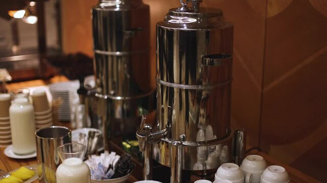 Set of coffee break lunch in the hotel restaurant during conference meeting, with tea and coffee catering, decorated banquet table with white tableware and metal tea maker machine boiler
