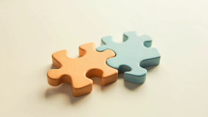 Obraz premium Interlocking Orange and Blue Puzzle Pieces on Cream Background, Connectivity Concept.