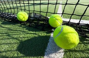 Bright greenish, yellow tennis ball on freshly painted court