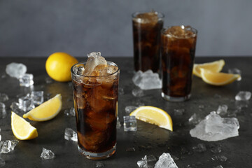 Fresh iced cola and lemon slices on dark grey table