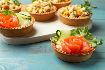 Tartlets with delicious fillings on blue wooden table, closeup