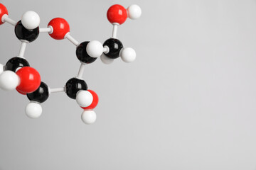 Molecule of glucose on light grey background, closeup and space for text. Chemical model