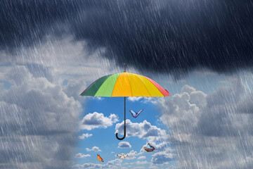 Butterflies flying in blue sky under open colorful umbrella during heavy rain