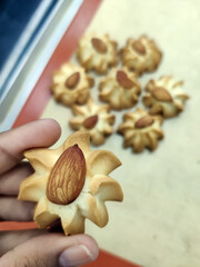 Freshly baked almond cookies are beautifully arranged in a bakery, showcasing their golden color and nutty topping, perfect for dessert lovers