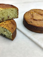 A delicious cake sits alongside slices on a cutting board, showcasing its moist texture and inviting aroma in a warm bakery atmosphere