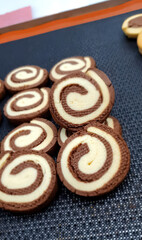 Circular cookies are perfectly arranged in rows displaying a delightful combination of chocolate and vanilla flavors