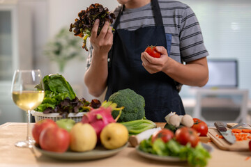 A person is holding a tomato and a bunch of broccoli