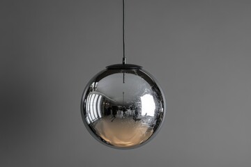Fototapeta premium A Shiny Metallic Sphere Lamp Hanging From the Ceiling