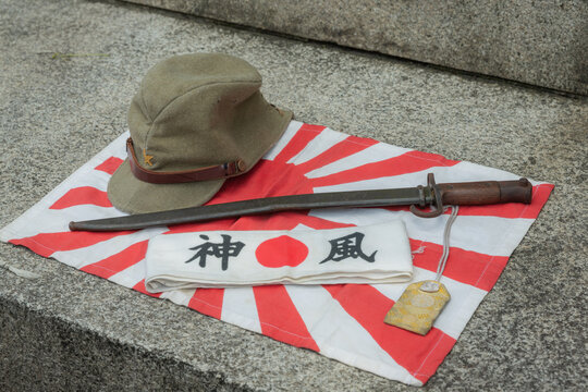 Japanese soldier's military cap, sword, banner with words of kamikaze, and national flag at war time of world war 2 displayed in yasukuni shinto shrine