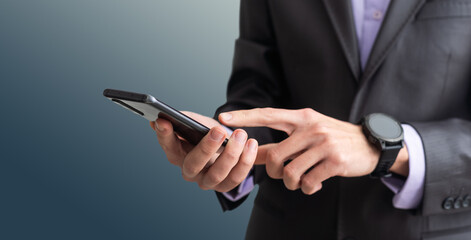 Businessman in the suit is using smartphone