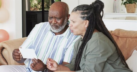 Happy black couple announcing pregnancy to senior parents and making toast in living room