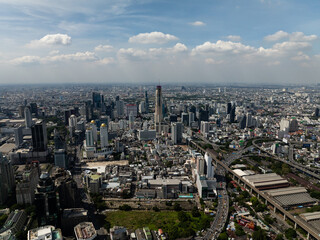 Obraz premium Panoramic view of a city skyline highlighting urban greenery and tall buildings under a bright sky. Bangkok, Thailand.