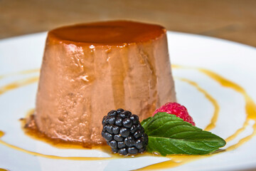 Hazelnut flan, flan with red berries topped with caramel sauce, hazelnut pudding