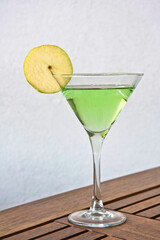 Green apple martini, apple cocktail on a wooden table