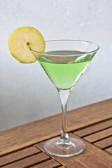 Green apple martini, apple cocktail on a wooden table