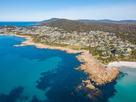 Aerial view of a coastal town behind a rocky shoreline