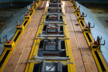 Top view of rowing simulator with seats for rowers and oars in sports pool. Aquatic water sports, preparation to competition, sports equipment, train endurance technique, rowing championships