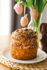 Beautifully decorated Easter cake topped with icing and chocolate sprinkles sits alongside a chocolate bunny and pastel eggs. The cheerful arrangement radiates holiday joy.