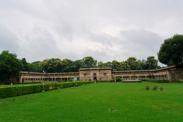 Colonial-era stone building with arched corridors in Sarnath, Varanasi, surrounded by manicured...