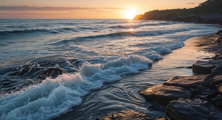 Ocean waves gently lapping against rocky shoreline during sunrise