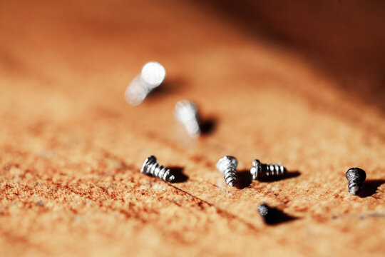 Tiny screws on wooden tabletop