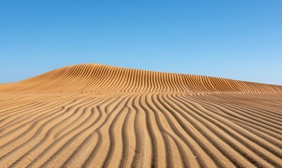Naklejka premium Desert landscape features rippled sand formations under a bright blue sky
