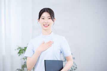 カルテを持った看護師のカメラ目線の笑顔のおまかせの信頼信用ポーズ