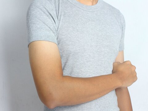 Tan line sleeves. Indonesian man's arm skin turns half tan after sunbathing. Isolated on white background