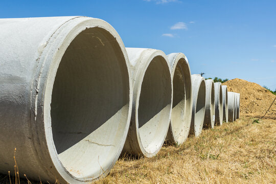 Low angle view of a row of large cement pipes