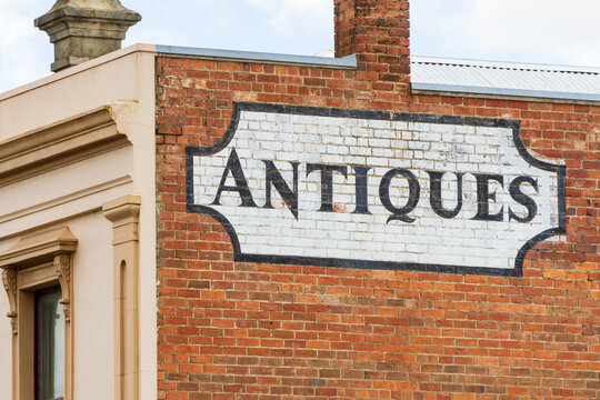An antique sign painted onto the side of a brick wall of an historic building