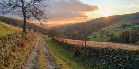 Fototapeta premium A peaceful countryside scene with the sun setting behind rolling hills