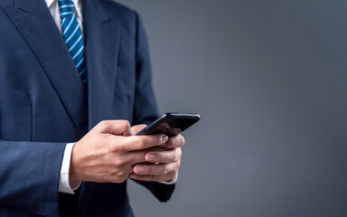 businessman using a smartphone for digital communication in a modern professional setting. The image reflects mobile technology and business connectivity.