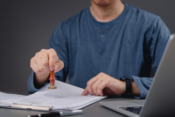 professional office worker using a stamp on paperwork, demonstrating the administrative process and...