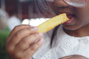 Child enjoying a crispy snack at a dining location