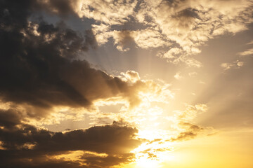 Sun and rays, sky clouds nature background. Stunning view of golden clouds and gradient blue gray sky on sunset