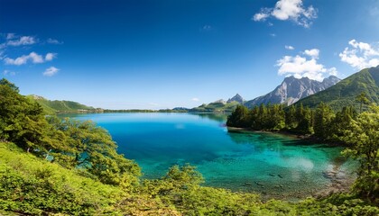 beautiful mountain landscape with clear blue water and vibrant greenery during bright sunny day