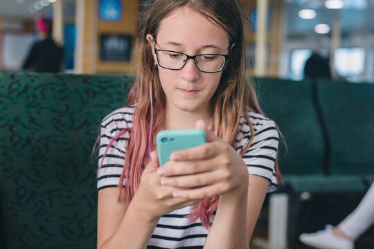 teen looking at photos on her phone