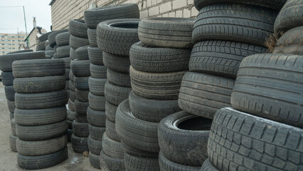 Storage of discarded old car tires outdoors, showcasing a pile of used tires ready for recycling. Highlighting environmental concerns and rubber waste management © kalyanby