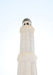 Fototapeta premium A serene white mosque minaret against a bright sky