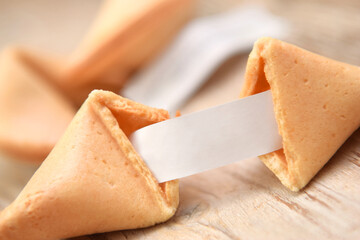 Fortune cookies broken in group with piece of paper closed up on the table