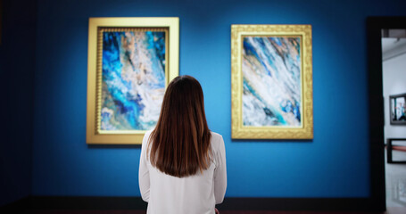 The young woman in the contemporary art gallery is exploring vibrant paintings
