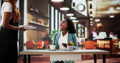 The African American waitress is bringing morning coffee