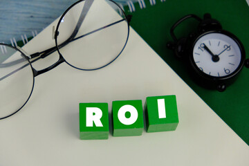wooden cube with letters ROI. Return on Investment (ROI)