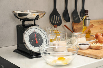Retro mechanical kitchen scale and different food products on white marble countertop indoors