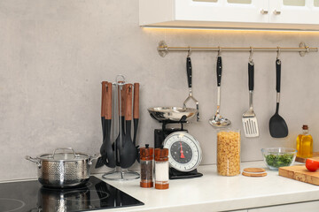 Retro mechanical kitchen scale, other utensils and different food products on white marble...