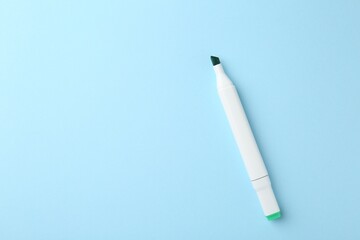 One color double sided marker on light blue background, top view. Space for text